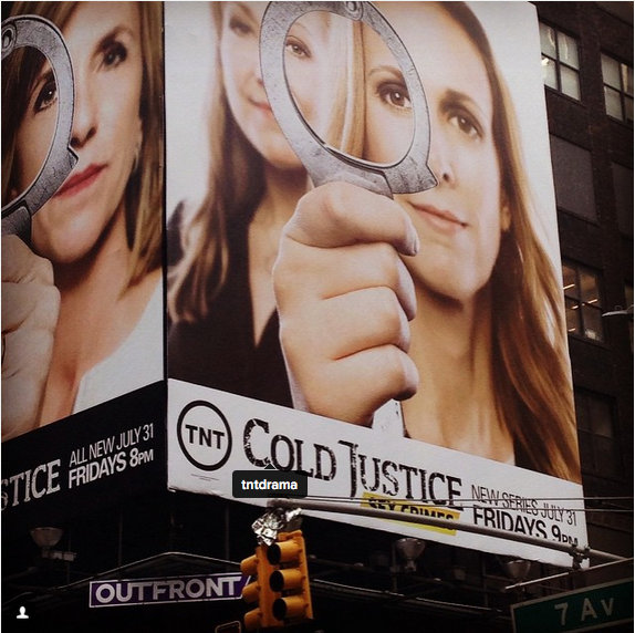 Billboard saying "TNT Cold Justice: Sex Crimes" written beneath a portrait of two women holding handcuffs. 